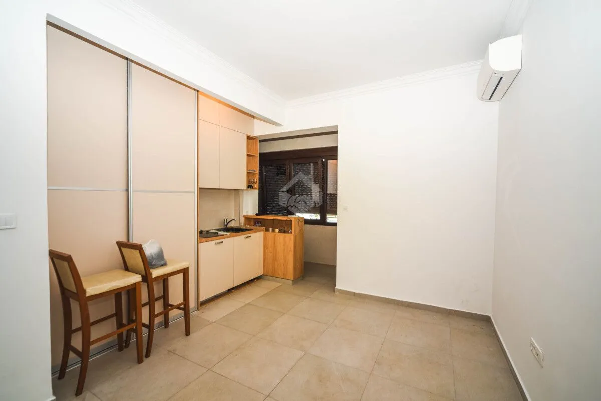 Smaller kitchen with built-in closets and bar stools.