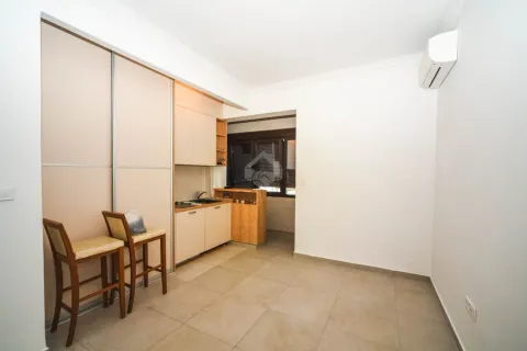 Smaller kitchen with built-in closets and bar stools. - image 3