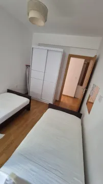 Bedroom with two single beds and a wardrobe. - image 22