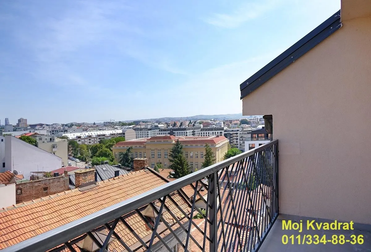 Pogled sa balkona na gradske krovove i okolne zgrade.