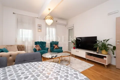 Dnevna soba sa garniturom, televizorom i trpezarijskim stolom u prvom planu. - image 7