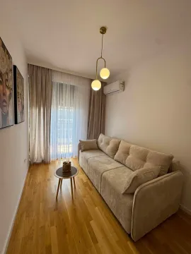 Living room with a sofa, small table, and decorative lighting. - image 5