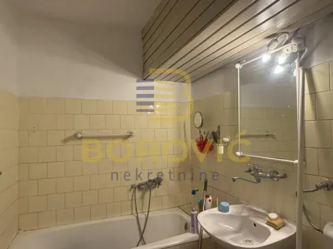 Starije kupatilo sa kadom, umivaonikom i pločicama na zidovima. - image 6
