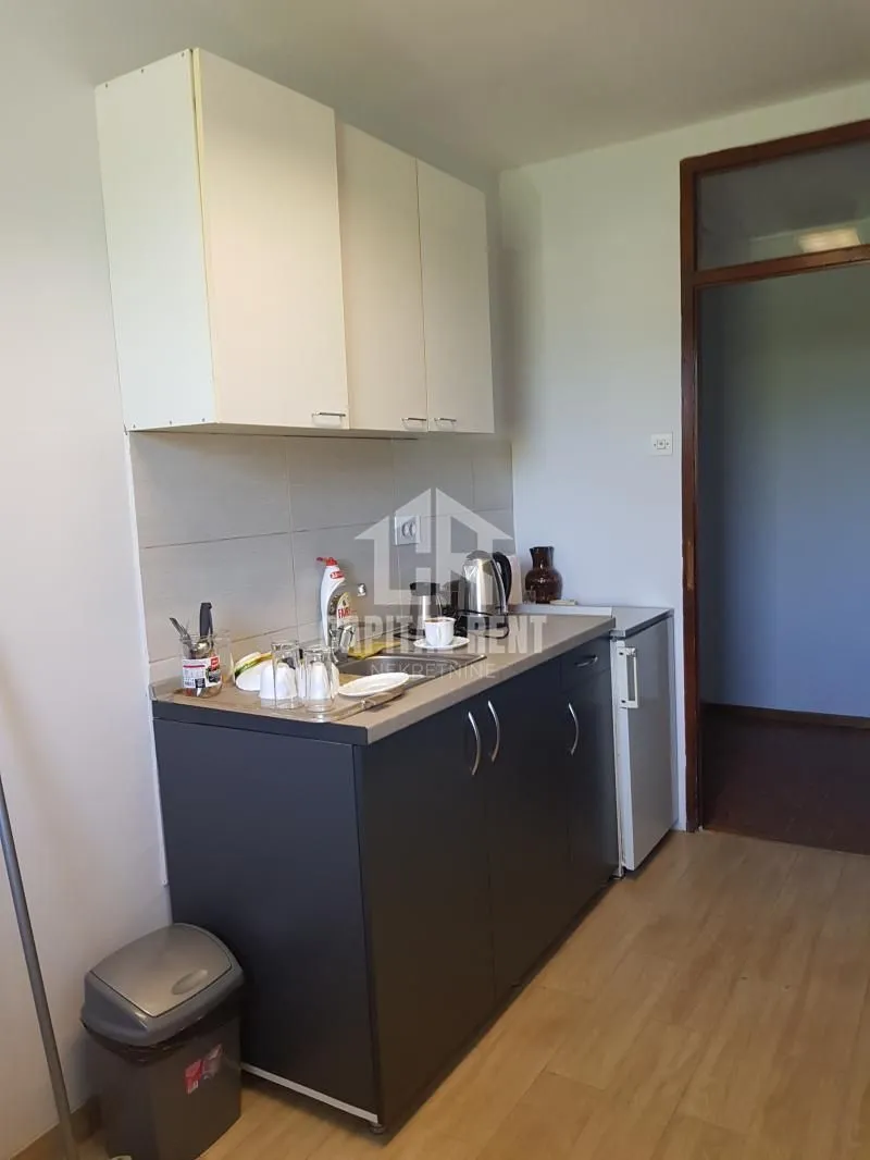 Small kitchen with lower and upper cabinets and a refrigerator.
