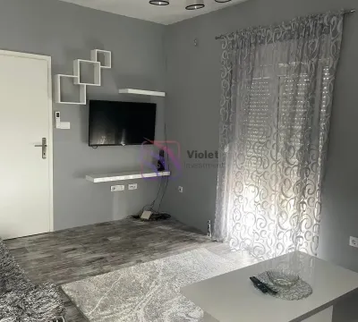 Living room with gray walls, a TV, and white furniture. - image 6