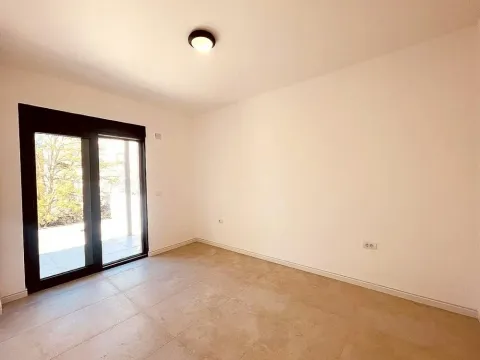 Empty room with tiled floors and glass doors leading to the terrace. - image 8