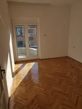 Prazna soba sa lakiranim parketom i balkonskim vratima. - image 6