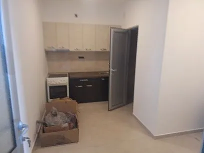 Smaller kitchen with lower and upper cabinets and a stove. - image 4