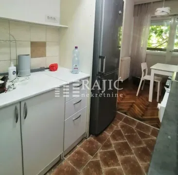 Smaller kitchen with white cabinets and a dining table. - image 6