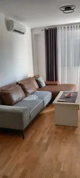 Bright living room with a sectional sofa and coffee table. - image 10
