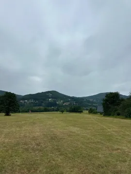 Pogled na prostranu livadu i okolna brda. - image 3