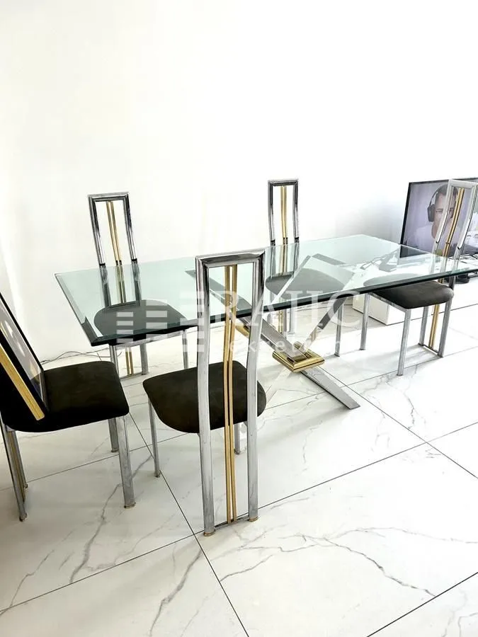 Dining area with a glass table and chairs.