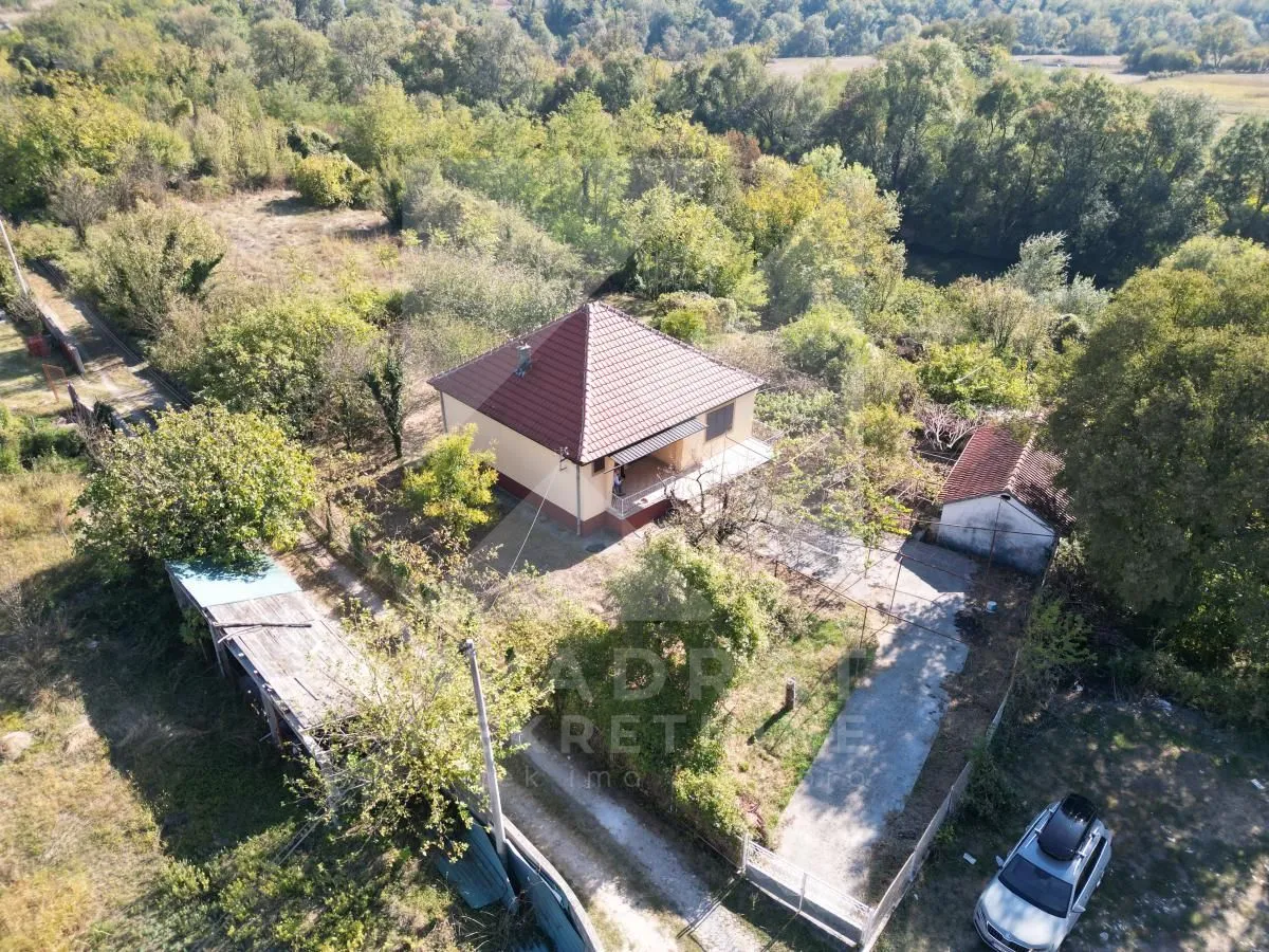 Pogled iz vazduha na kuću sa dvoriijem i zelenilom.