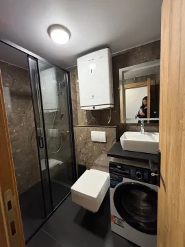 Savremeno opremljeno kupatilo sa tuš kabinom i veš mašinom. - image 7