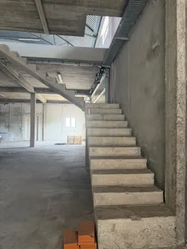 View of the interior of a building in a rough construction phase with concrete stairs. - image 4