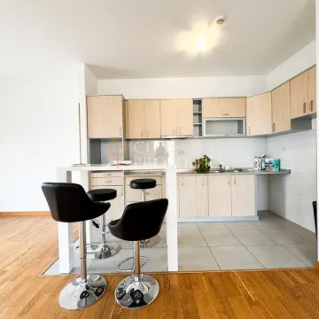 Kitchen with wooden cabinetry, a breakfast bar, and black bar stools. - image 10