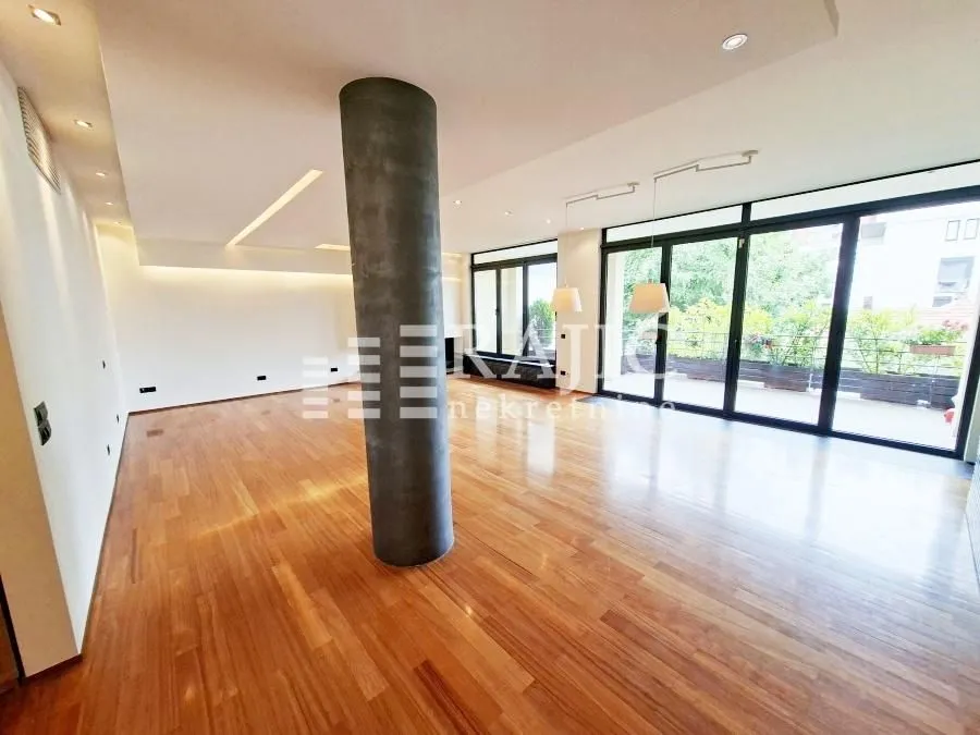 Spacious bright living room with parquet flooring and terrace access.