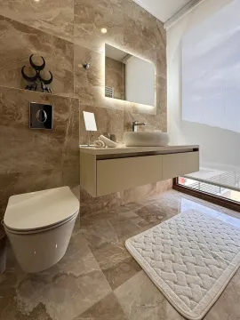 Modern bathroom clad in marble tiles with a wall-mounted vanity and toilet. - image 6