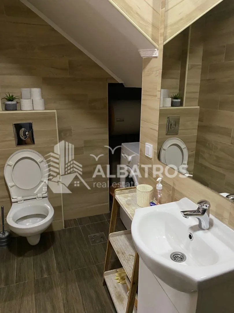 Tiled bathroom with a washbasin and a toilet.