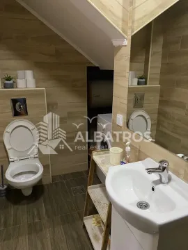 Tiled bathroom with a washbasin and a toilet. - image 11