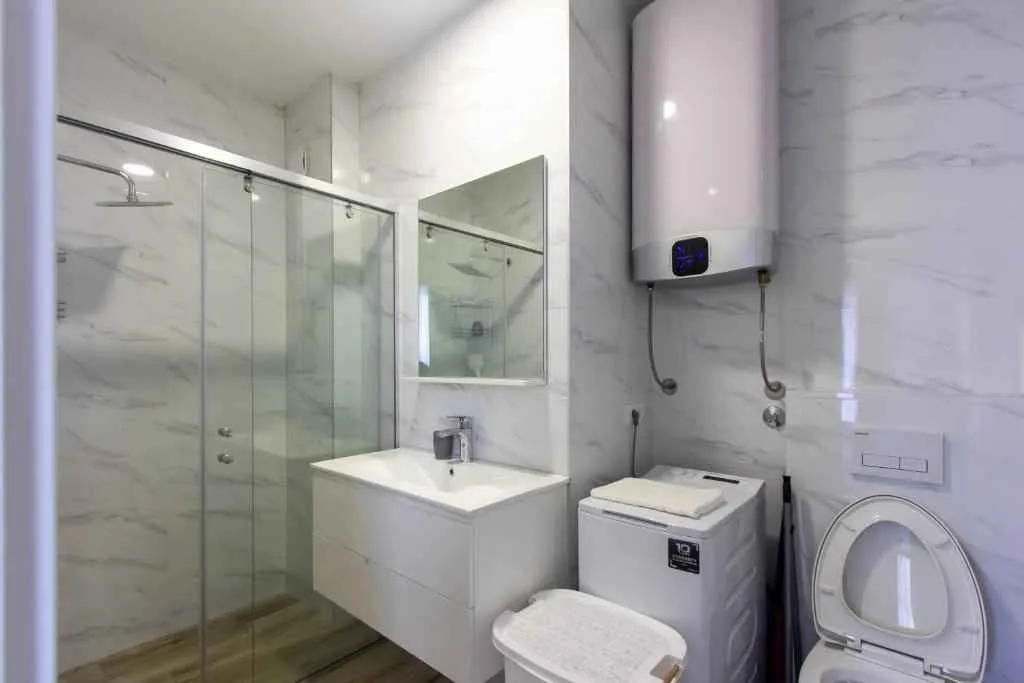 Moderne kupatilo sa tuš kabinom, umivaonikom, veš mašinom i bojlerom.