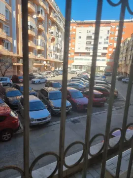 View from the window overlooking a shared parking lot and surrounding apartment buildings. - image 13