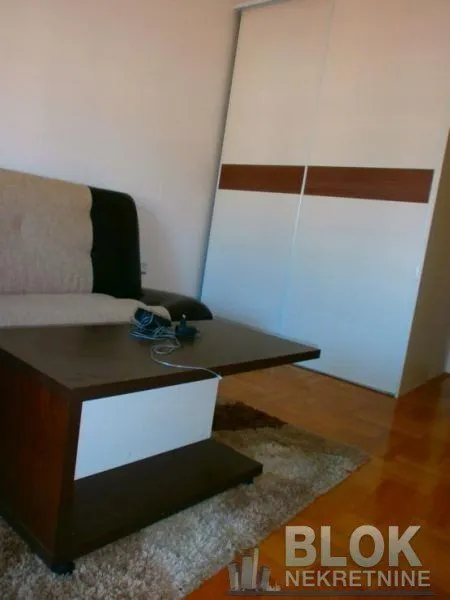 Living room with a sofa, coffee table, and wardrobe.