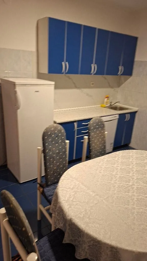 Kitchen with blue cabinets and a dining table in the foreground.