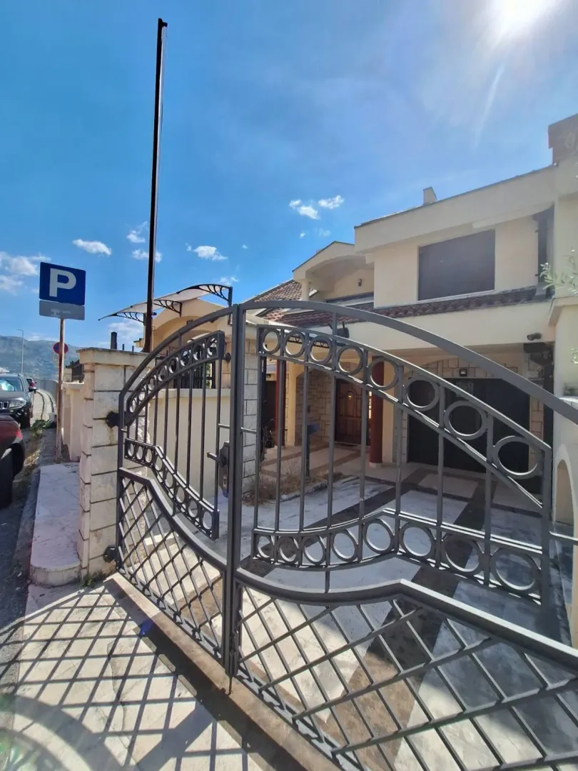 View of the entrance gate and courtyard of the house with parking.