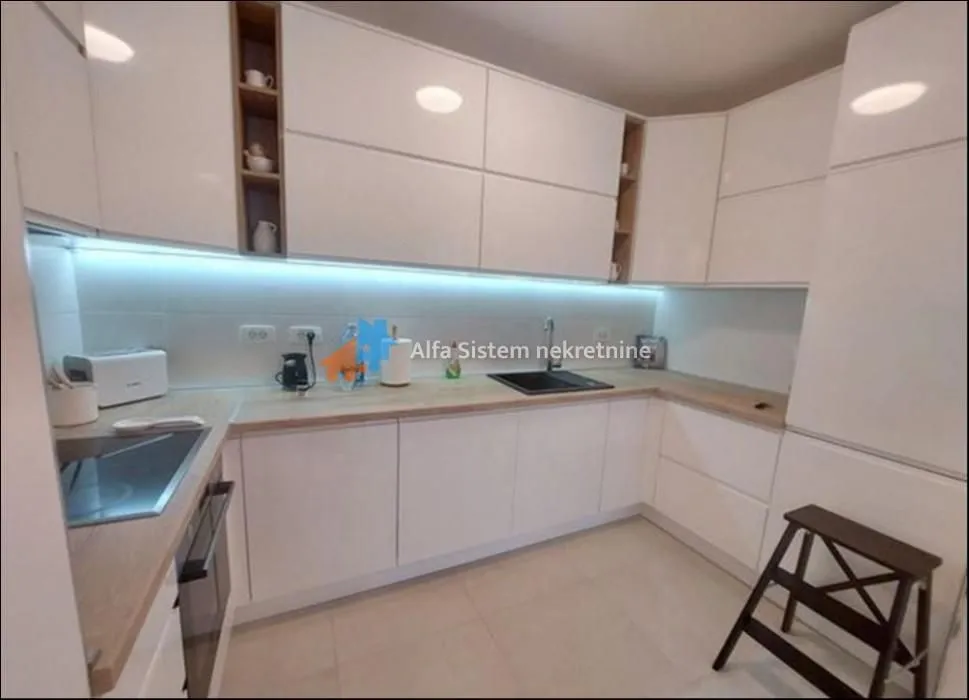 Modern kitchen with white cabinets and built-in appliances.