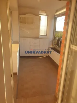 Zastakljeni balkon sa pločicama na podu i komodom. - image 4