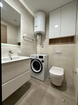 Moderno opremljeno kupatilo sa tuš kabinom, umivaonikom i veš mašinom. - image 9