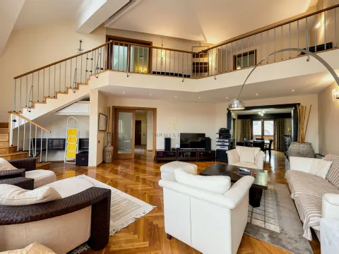 Spacious living room with seating area, wooden flooring, and a staircase leading to the gallery. - image 4