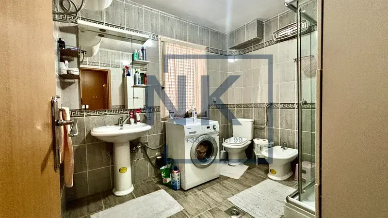 Bathroom equipped with sanitary fixtures, a shower cabin, and a washing machine.
