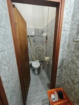 View through the doorway into a small tiled bathroom with a toilet. - image 9