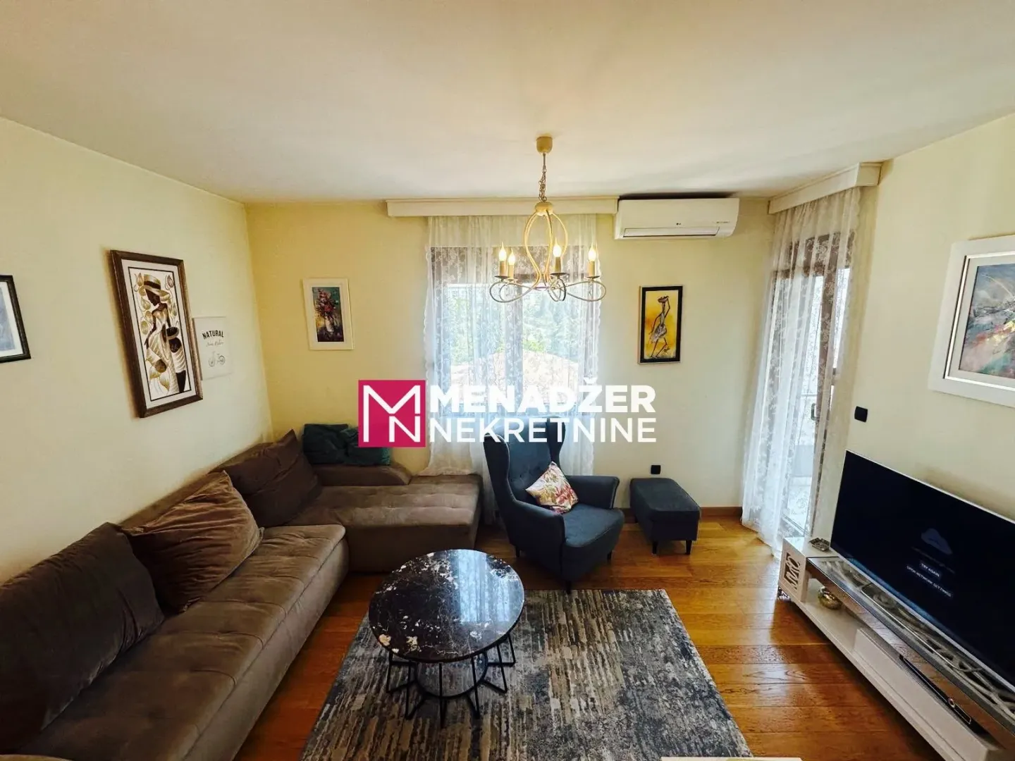 Spacious living room with sofa, coffee table, and television.