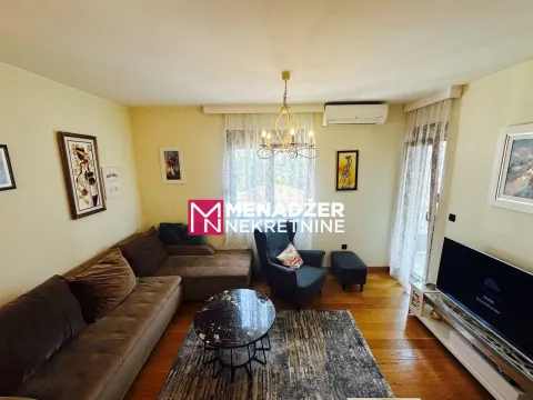 Spacious living room with sofa, coffee table, and television. - image 3
