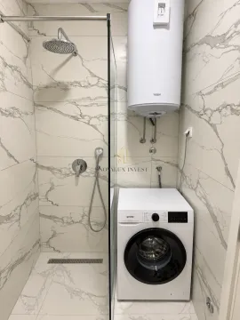 Bathroom with a shower cabin, water heater, and washing machine. - image 4