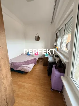 Small bedroom with a bed and a window next to which suitcases are placed. - image 6