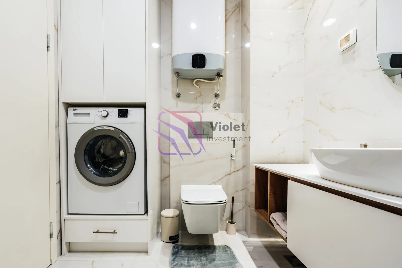 Modern bathroom with a washing machine, built-in water heater, and washbasin.