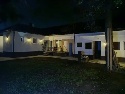 Noćni izgled kuće sa dvorištem i osvetljenom fasadom. - image 3