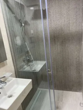 Kupatilo sa staklenom tuš kabinom i lavaboom. - image 10