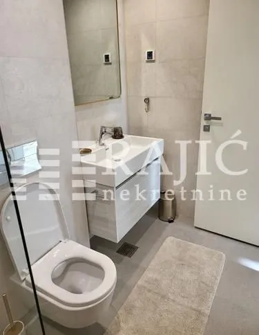 Modernly equipped bathroom with a washbasin and toilet.
