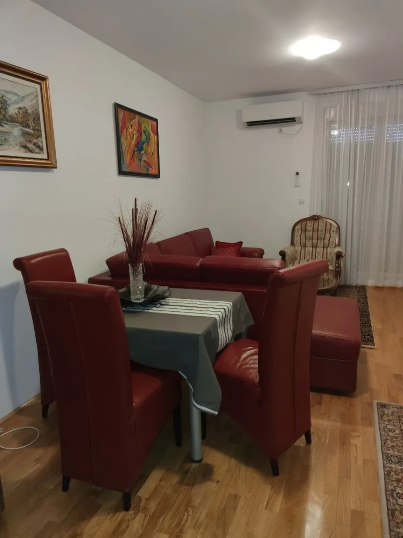 Living room featuring a dining table and red leather furniture.