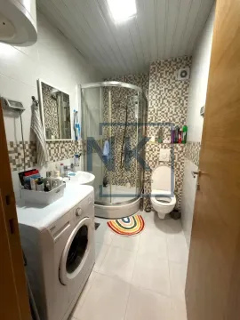 Bathroom equipped with a shower cabin, sink, toilet, and washing machine. - image 6