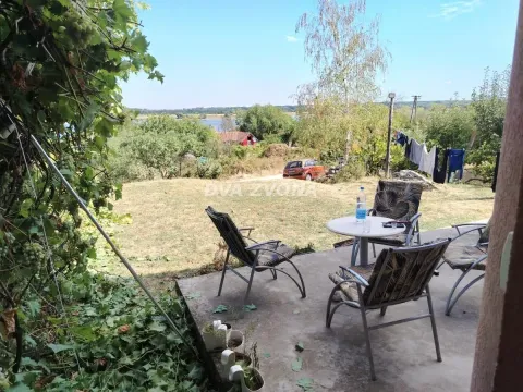 Nameštena terasa sa stolom i stolicama i pogledom na dvorište i prirodu. - image 3