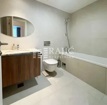 Modern bathroom with a sink, toilet, and bathtub. - image 12