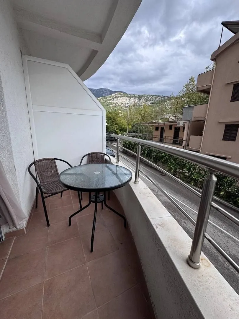 Small balcony with a table and chairs and a view of the surroundings.