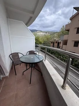 Small balcony with a table and chairs and a view of the surroundings. - image 8