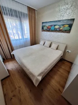 Namještena spavaća soba sa bračnim krevetom, drvenim podom i prozorom sa zavjesama. - image 16